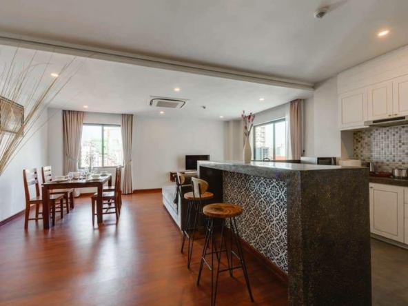 the kitchen and the living room of the 2-bedroom spacious beautiful serviced apartment for rent in BKK1 Phnom Penh Cambodia